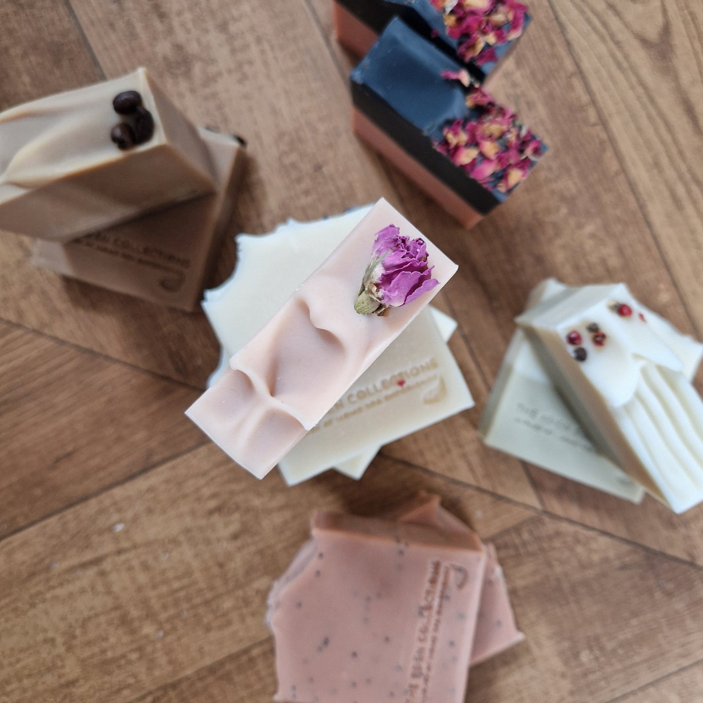 Five different handmade, cold-processed soap bars. The photo showcase these soaps' decorations and colours. These moisturising soaps are handmade by The Eden Collections.