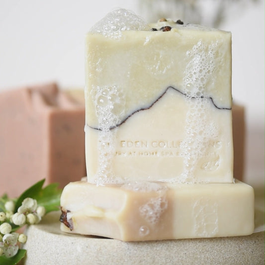 The Eden Collections rosemary & mint soap, showcased on a handmade ceramic plate with rosemary.