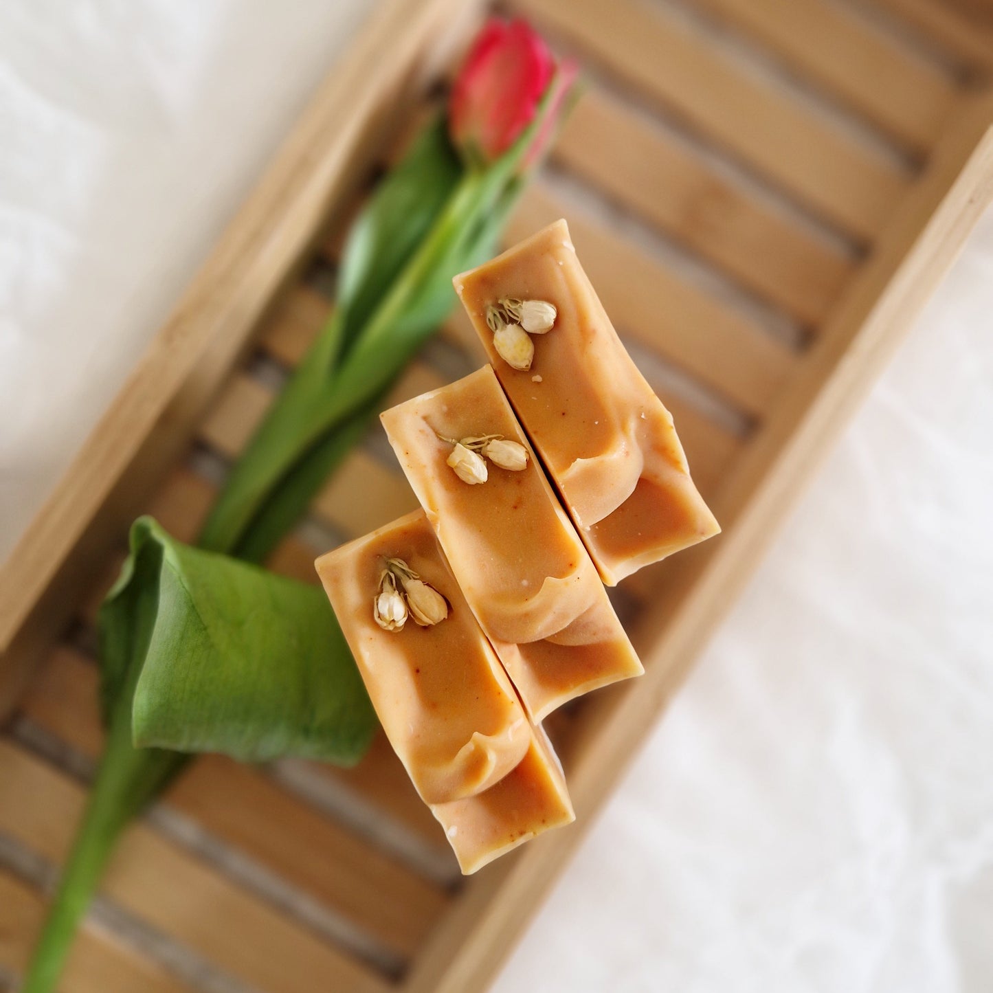 3 Summer Soap with zesty citrus scent. Natural soaps on a wooden bath tray with tulip. Handmade by The Eden Collections in Wales.