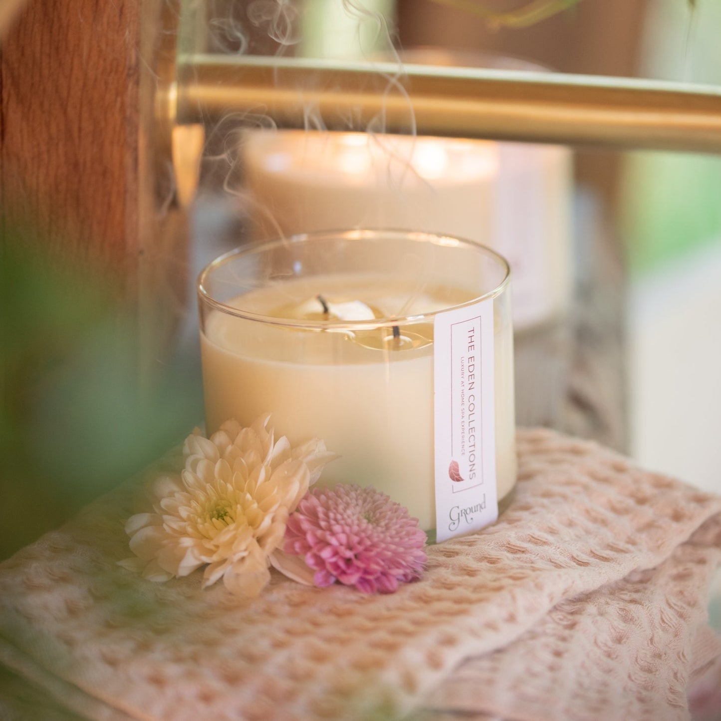 Blown out candle with smoke. Cosy, warm atmosphere with an aromatherapy soy wax candle by The Eden Collections. Matt gold tap. Beautiful bathroom.