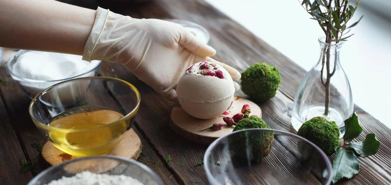 An image of The Eden Collections Secret Bath Bombs being made, displayed alongside ingredients laid out on a wooden worktop.