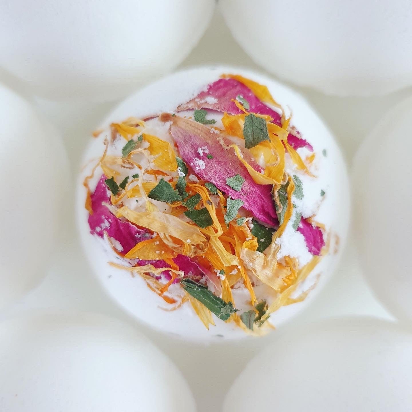A close up photograph of the Floral Relief Secret Bath Bomb, displaying the flower petals included in the bath bomb.