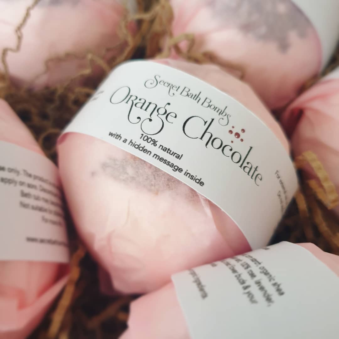 A range of Orange Chocolate Secret Bath Bombs displayed beautifully in their packaging eco-friendly, plastic free, tissue paper packaging.