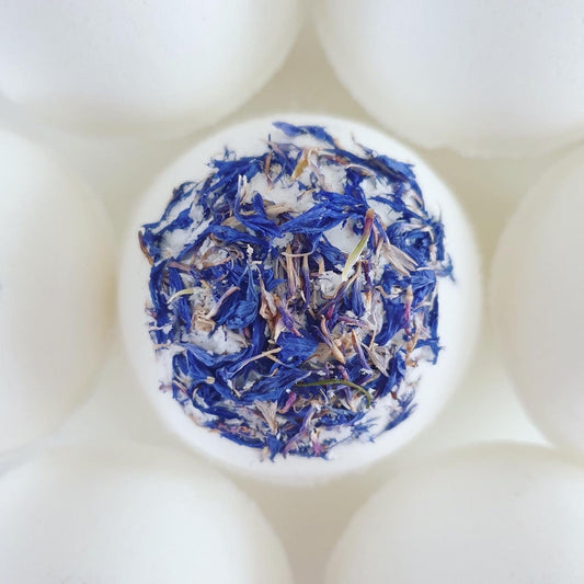 Three Butters Secret Bath Bomb, photographed from the top, decorated with blue cornflower. This unscented, organic bath bomb holds a hidden message inside and handmade by The Eden Collections. 