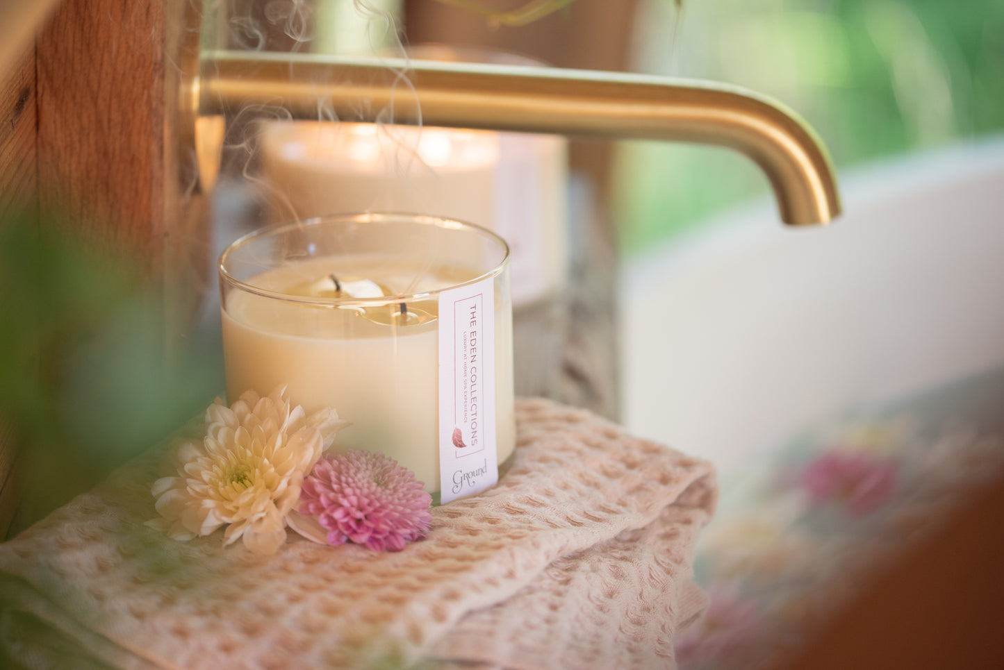 Blown out candle with smoke. Cosy, warm atmosphere with an aromatherapy soy wax candle by The Eden Collections. Matt gold tap. Beautiful bathroom.