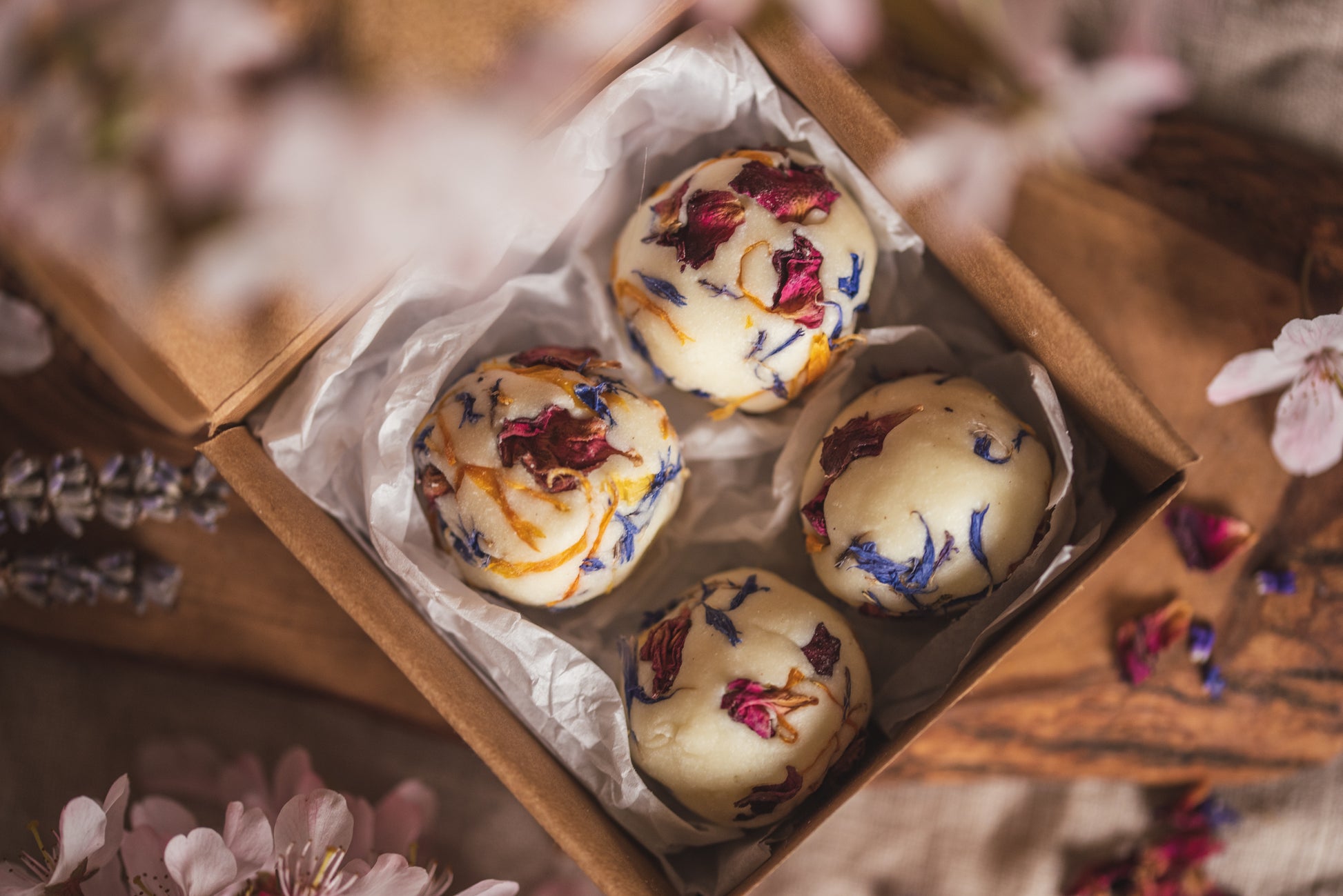 Moisturising, handmade bath creamers are placed in their packaging, a kraft box with tissue paper. These bath creamers are handmade in Wales by The Eden Collections.