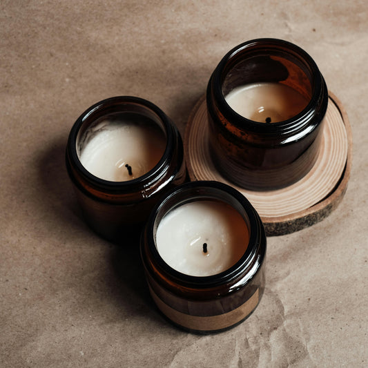 Three soy wax candles with festive scents in amber jars. Christmas Candle Collection by The Eden Collections.