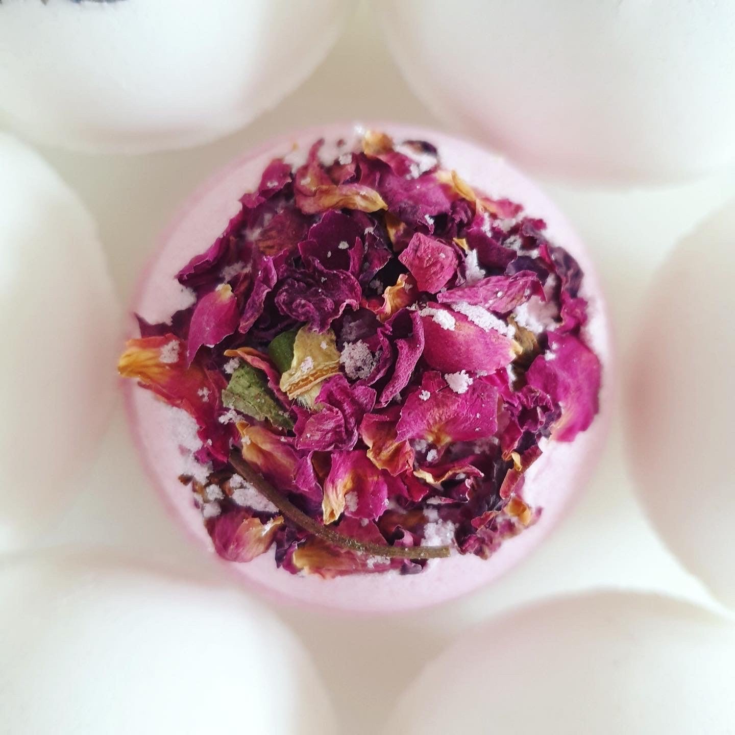 Anti-anxiety Secret Bath Bomb with vibrant pint colour thank you to beetroot powder. Scented with bergamot, lavender and ylang-ylang essential oils, decorated with dried rose petals, created by The Eden Collections. 