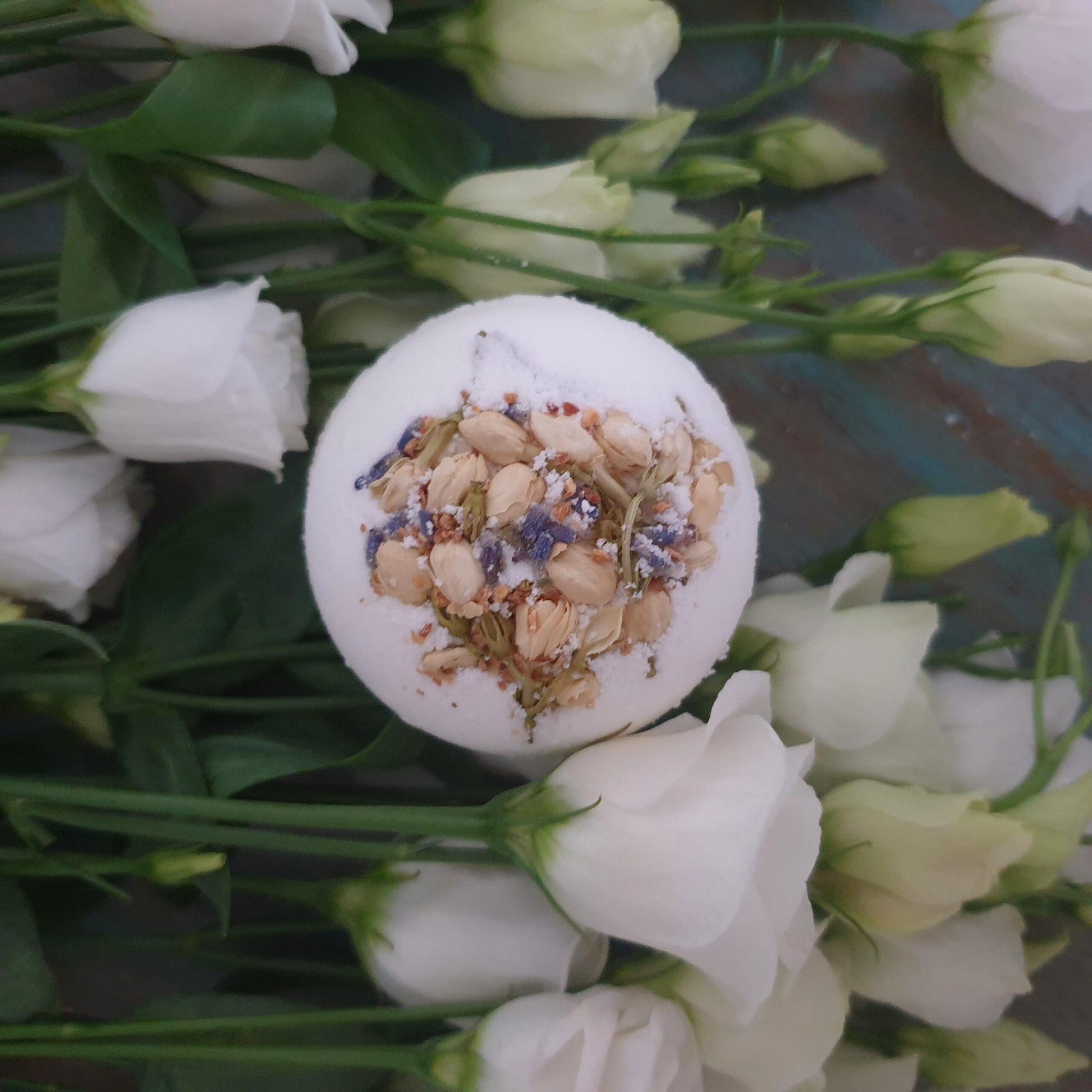The Breathe Secret Bath Bomb displayed alongside beautiful white roses.