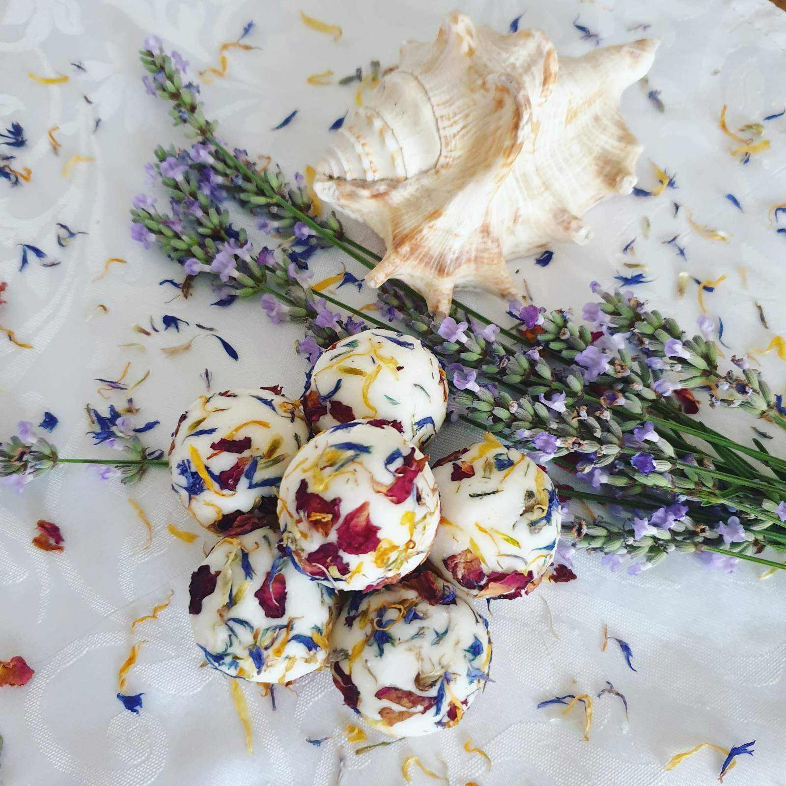 The Eden Collections floral scented bath creamers, showcased alongside lavender, petals and seashells.