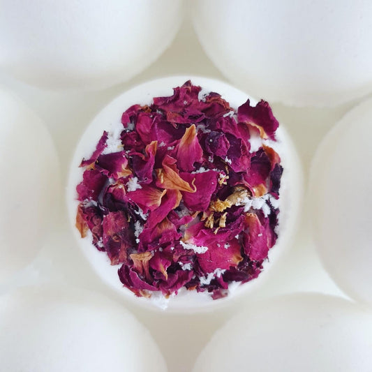 Rose & Sandalwood Secret Bath Bomb, decorated wit red dried rose petals. This luxurious bath bomb is handmade by The Eden Collections. 