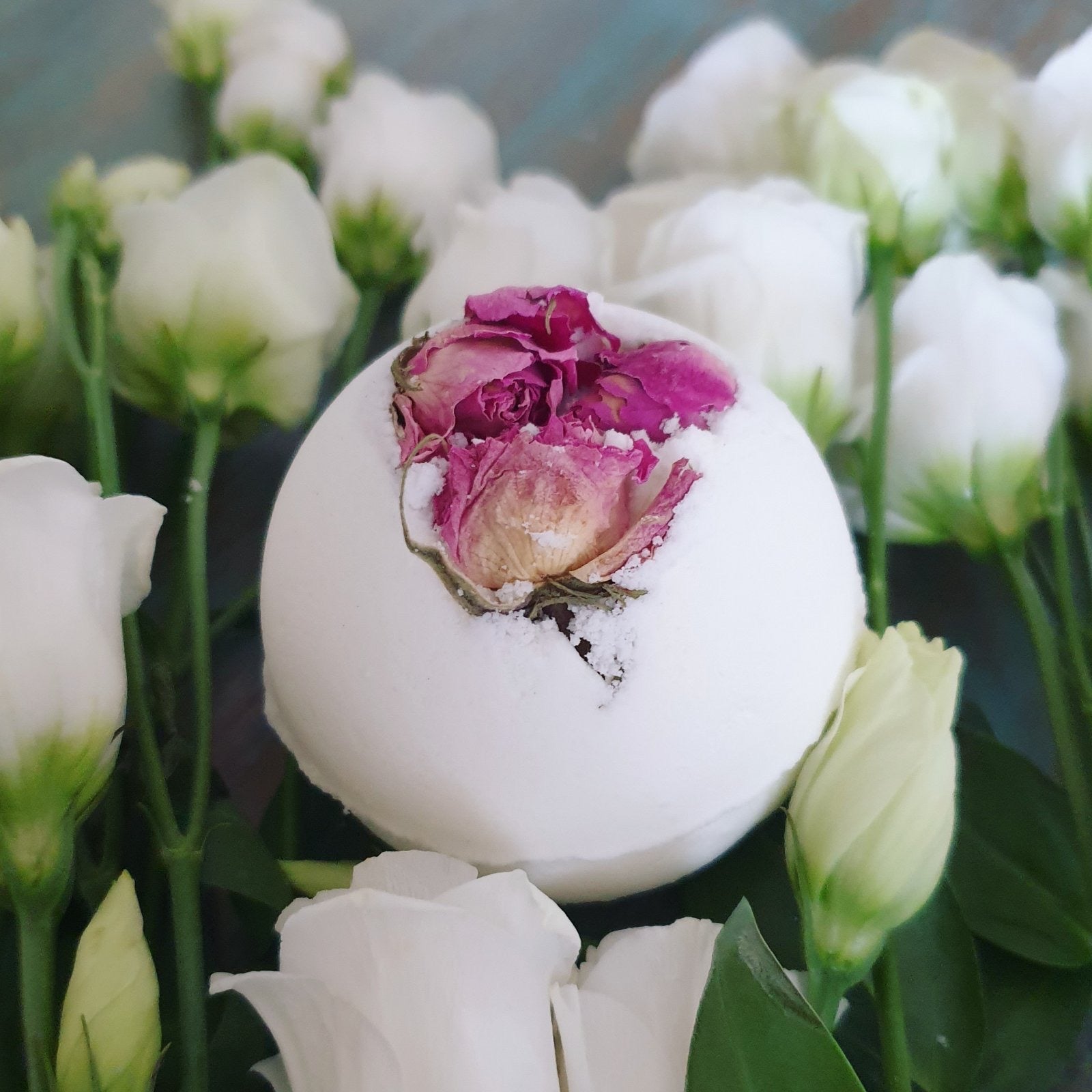 A close up photograph of the Rose Secret Bath Bomb, showcasing the natural organic ingredients such as dried rose petals.