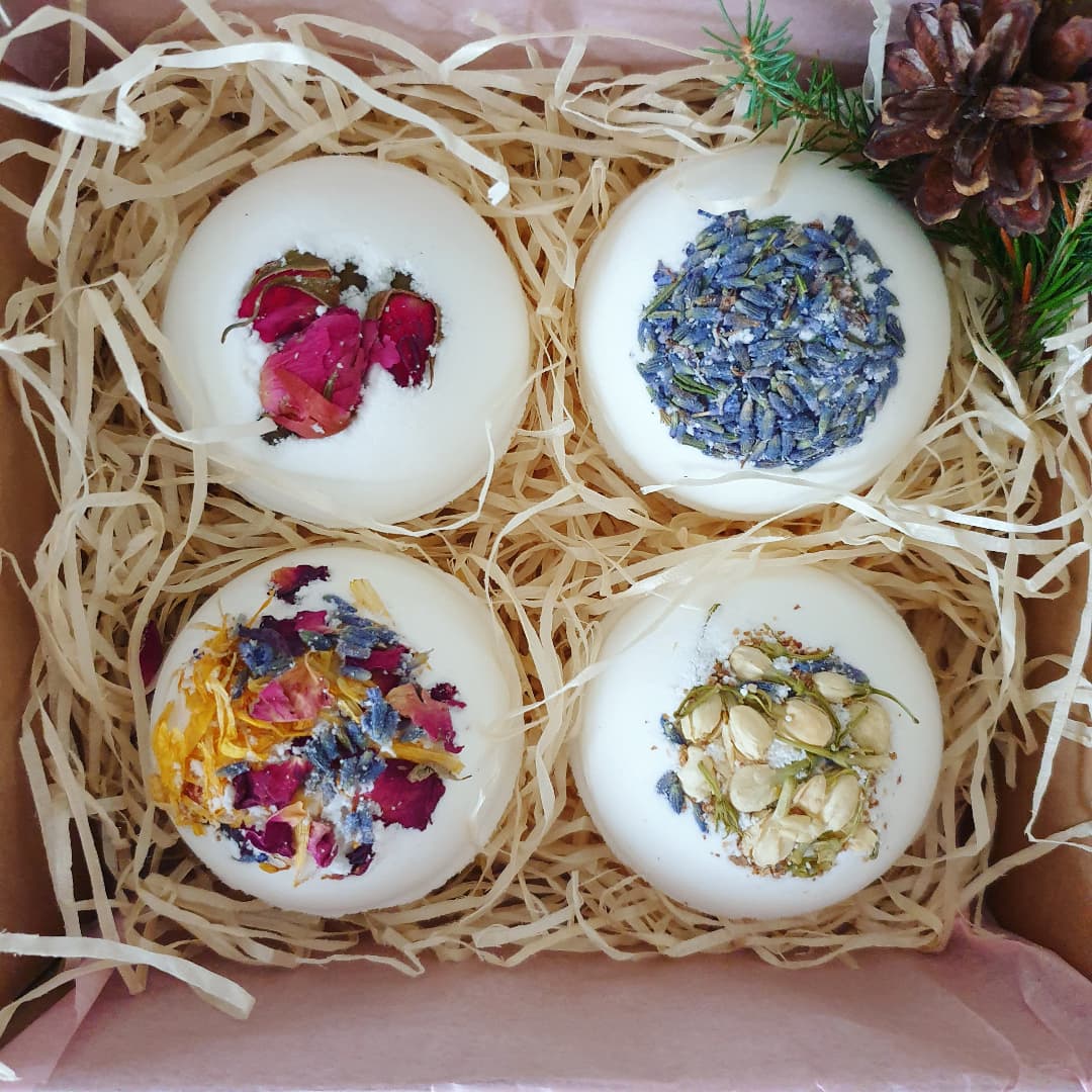 A close up photograph of The Eden Collections box of 4 Secret Bath Bombs, featuring Secret Bath Bombs in Lavender, Breathe, Rose, and Floral. 